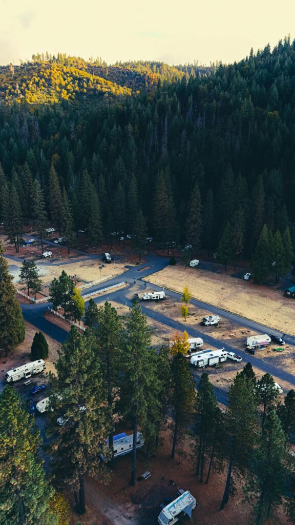 Scenic aerial view of RV camp in forest with autumn foliage.